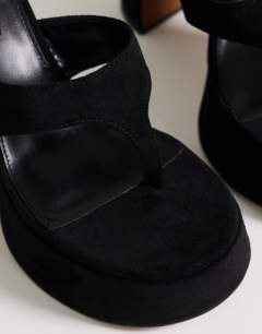 Model wearing Nima platform heeled toe thong sandal in black