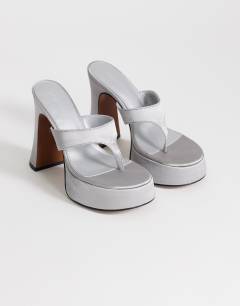 Model wearing Nima platform heeled toe thong sandal in grey satin