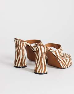 Model wearing Nima real leather with hair platform heeled toe thong sandal in zebra