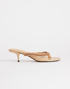 Model wearing Nolan beaded toe thong mid heel sandal in camel