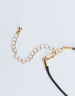 Model wearing Nora choker rope necklace with gem in gold