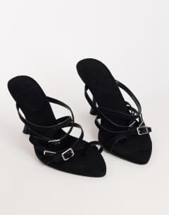 Model wearing Nori buckle detail heeled mule in black faux suede
