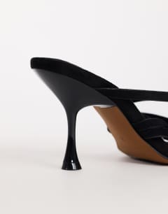 Model wearing Nori buckle detail heeled mule in black faux suede