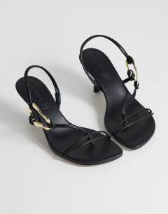 Model wearing Nova strappy mid heeled sandal with hardware in black