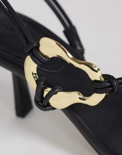 Model wearing Nova strappy mid heeled sandal with hardware in black