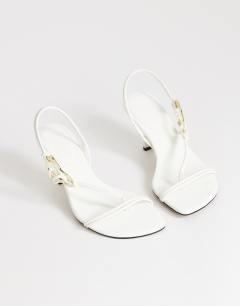 Model wearing Nova strappy mid heeled sandal with hardware in white