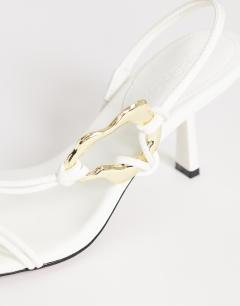 Model wearing Nova strappy mid heeled sandal with hardware in white