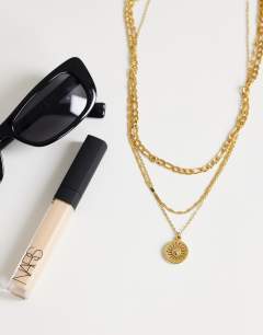 Model wearing Nyle stainless steel multi chain necklace with pendants in gold