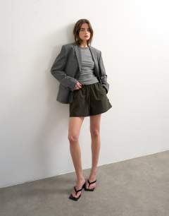 Model wearing Nylon runner short with insert ties in dark green