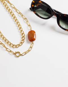 Model wearing Oakley stainless steel multi chain necklace with orange stone in gold