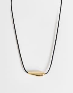 Model wearing Octavia collar length necklace in black with gold detail