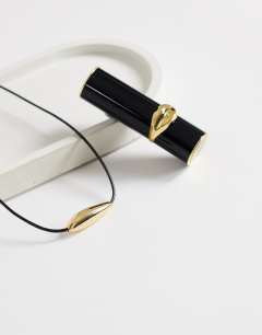 Model wearing Octavia collar length necklace in black with gold detail