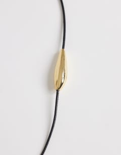 Model wearing Octavia collar length necklace in black with gold detail