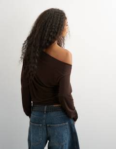 Model wearing Off shoulder long sleeve top in deep mahogany
