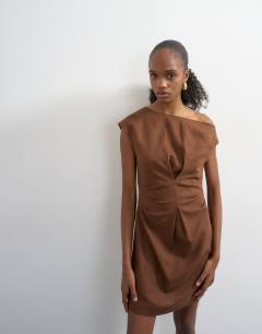 Model wearing Off shoulder tucked waist mini linen dress in chocolate