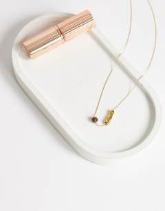 Model wearing Olivio stainless steel necklace in gold with brown bead