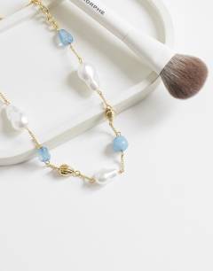Model wearing Omelia necklace in faux pearl, gold and blue