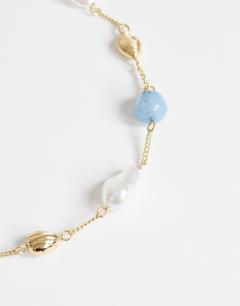Model wearing Omelia necklace in faux pearl, gold and blue