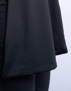 Model wearing One shoulder cape detail top in black