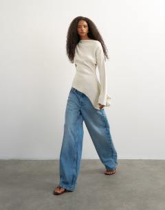 Model wearing One shoulder long sleeve draped top in ecru