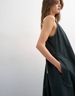 Model wearing Open back buckle strap maxi sundress with contrast topstitching in black