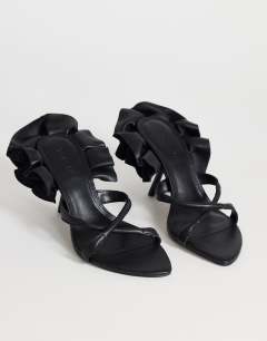 Model wearing Ophelia real leather high heeled sandal with ruffle in black
