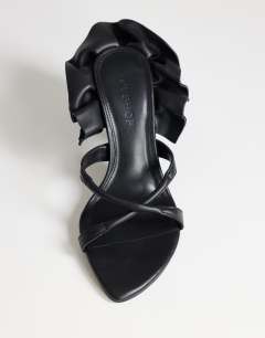 Model wearing Ophelia real leather high heeled sandal with ruffle in black