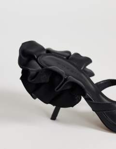 Model wearing Ophelia real leather high heeled sandal with ruffle in black