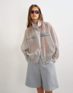 Model wearing Organza funnel neck bomber with contrast binding in grey