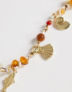 Model wearing Orla bead necklace with gold charms in orange multi