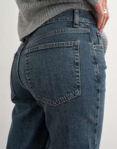 Model wearing Orson comfort stretch straight leg ankle grazer jean in blue black