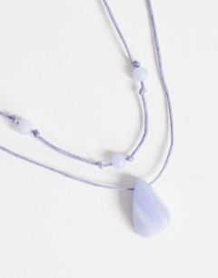Model wearing Ottie cord necklace with semi precious stones in light blue