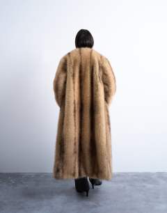 Model wearing Oversized faux fur collarless long coat in natural stripe in beige