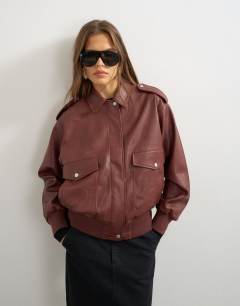 Model wearing Oversized faux leather bomber jacket in burgundy
