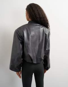 Model wearing Oversized faux leather oversized zip up bomber jacket in washed black