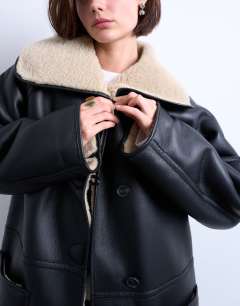 Model wearing Oversized longline coat in black and cream