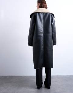 Model wearing Oversized longline coat in black and cream