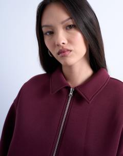 Model wearing Oversized scuba-style fabric zip through jacket in burgundy