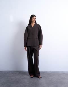 Model wearing Ovoid collarless suit blazer in chocolate