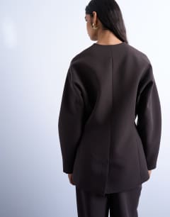 Model wearing Ovoid collarless suit blazer in chocolate