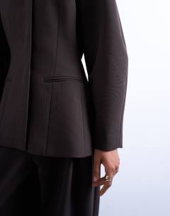 Model wearing Ovoid collarless suit blazer in chocolate