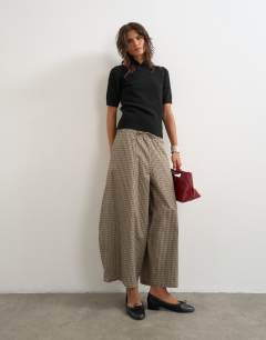 Model wearing Ovoid mid length trouser in brown check