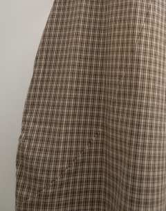 Model wearing Ovoid mid length trouser in brown check