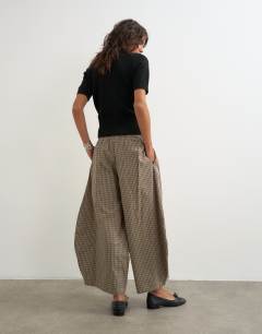 Model wearing Ovoid mid length trouser in brown check