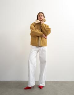 Model wearing Ovoid shearling jacket in tan