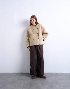 Model wearing Ovoid short shearling double breasted jacket in cream