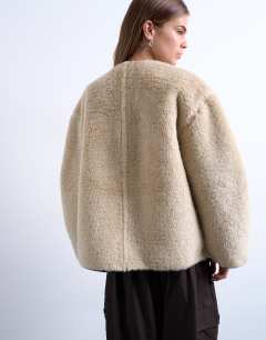Model wearing Ovoid short shearling double breasted jacket in cream