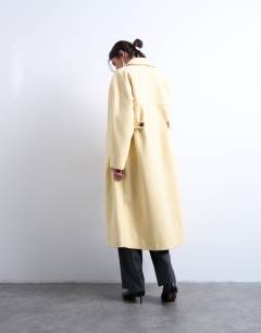 Model wearing Ovoid sleeve double breasted longline formal coat in buttermilk