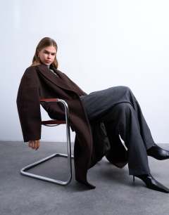 Model wearing Ovoid sleeve double breasted longline formal coat in chocolate