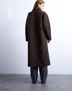 Model wearing Ovoid sleeve double breasted longline formal coat in chocolate